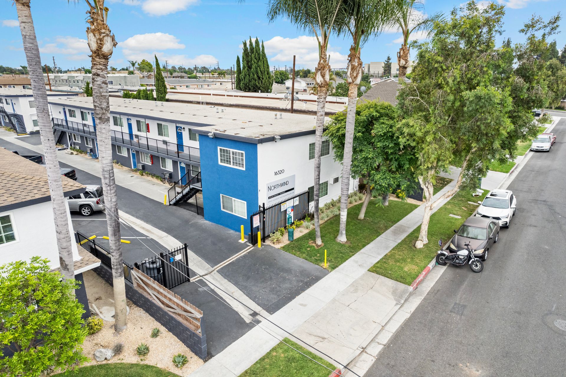 Gallery of exterior and interior photos of Northwind. Including walkways, gray archways, blue front doors, bbq grills, bedrooms with furniture, gated entrances, and main office.