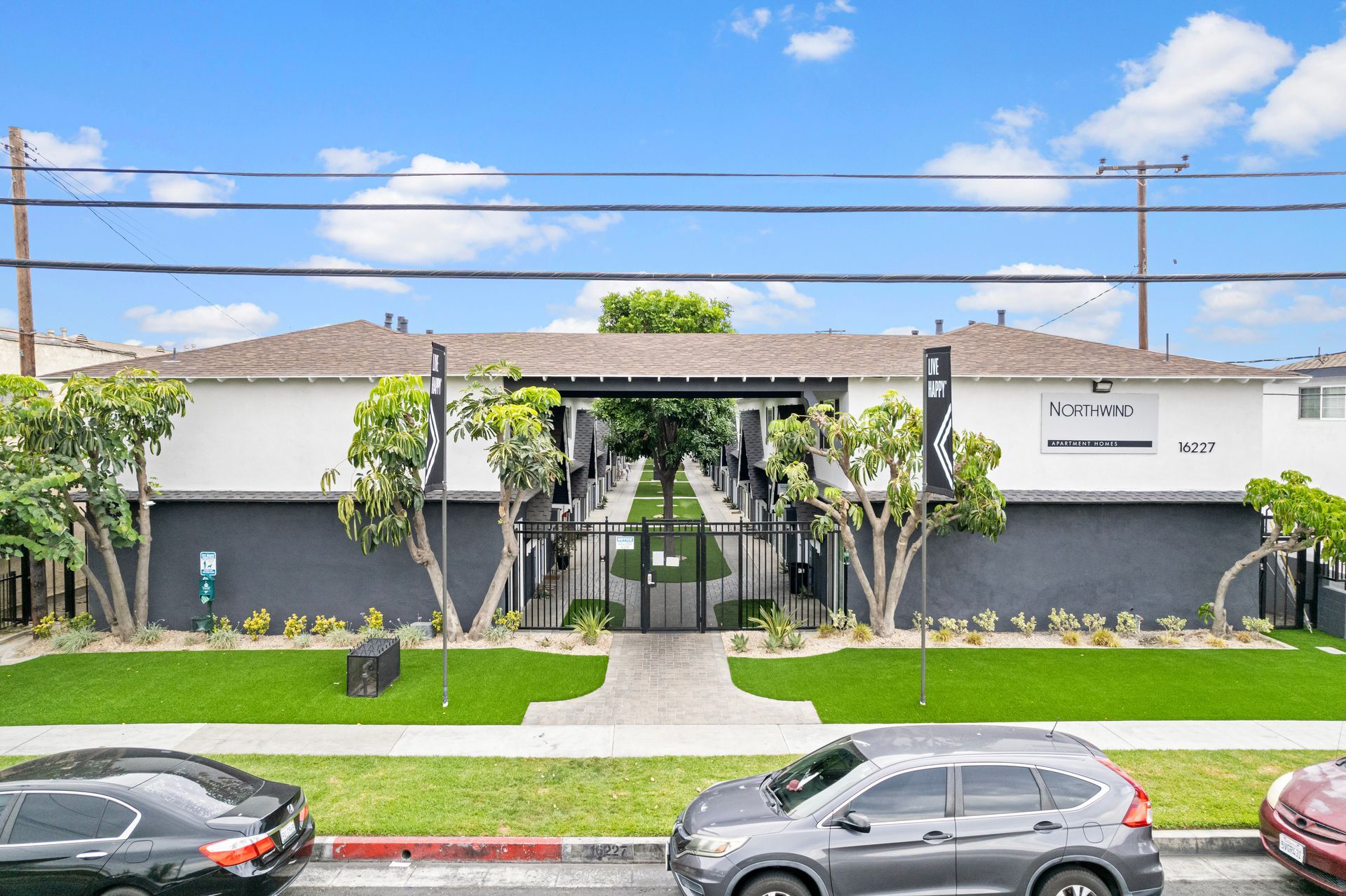 Gallery of exterior and interior photos of Northwind. Including walkways, gray archways, blue front doors, bbq grills, bedrooms with furniture, gated entrances, and main office.