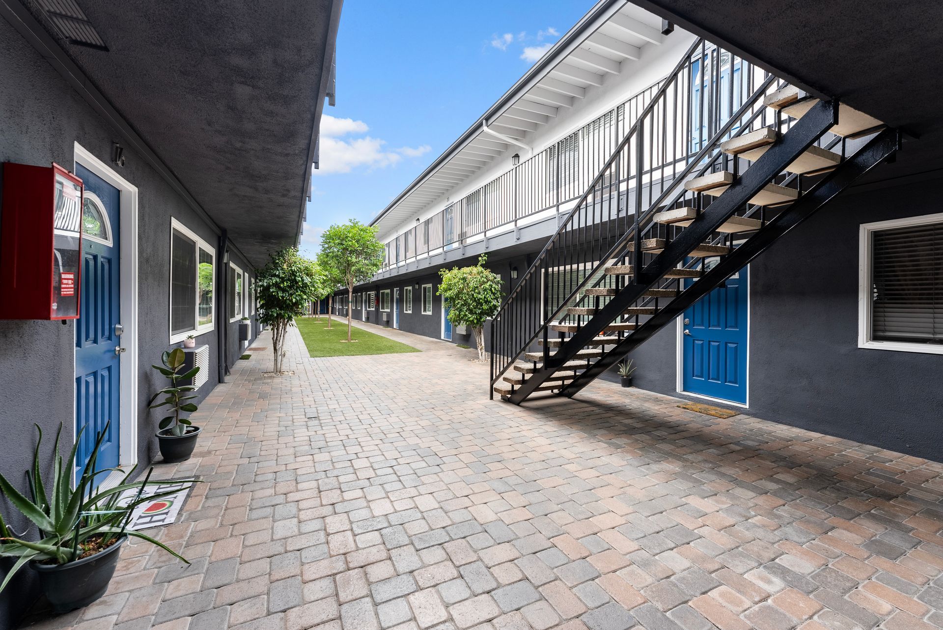 Gallery of exterior and interior photos of Northwind. Including walkways, gray archways, blue front doors, bbq grills, bedrooms with furniture, gated entrances, and main office.