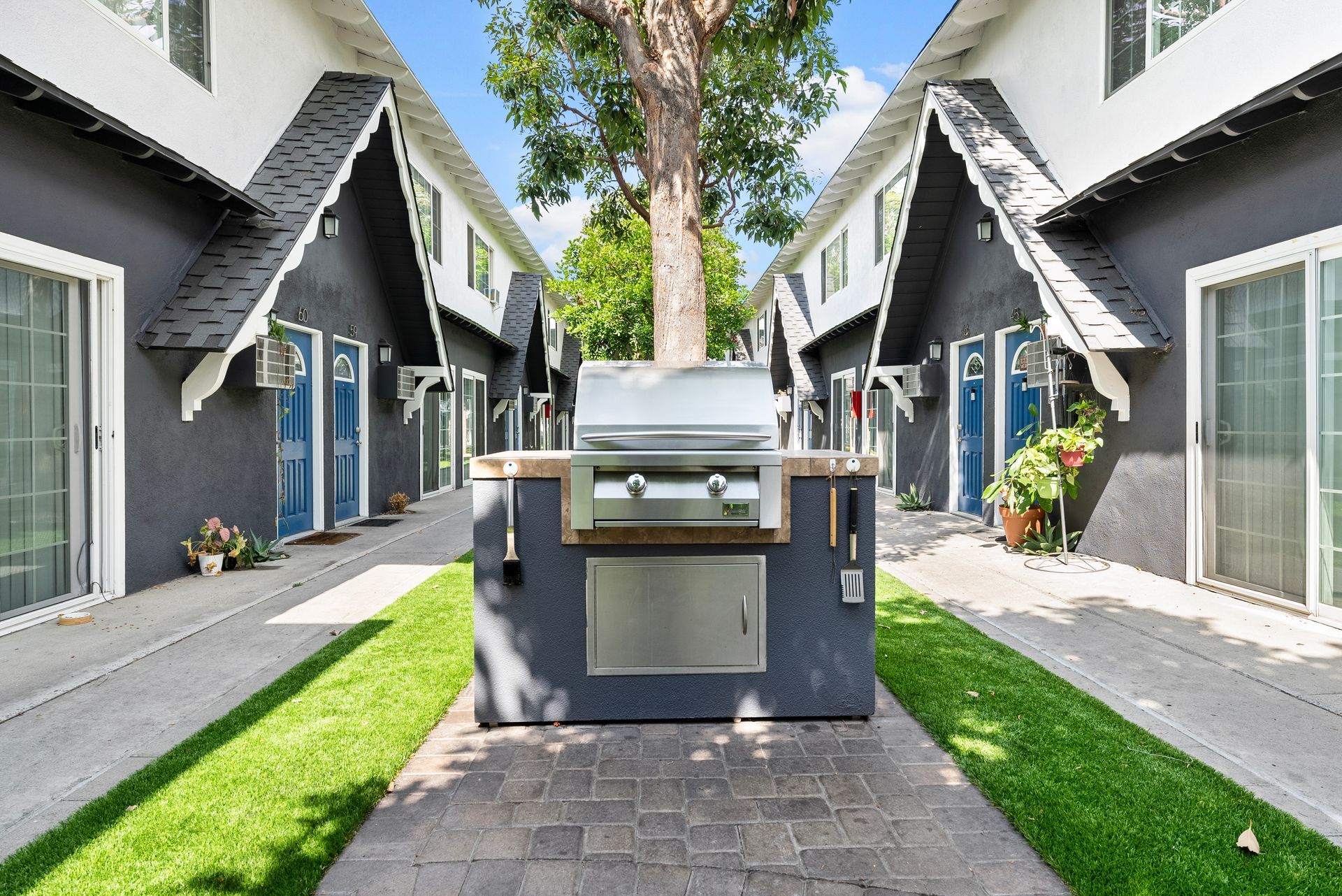Gallery of exterior and interior photos of Northwind. Including walkways, gray archways, blue front doors, bbq grills, bedrooms with furniture, gated entrances, and main office.
