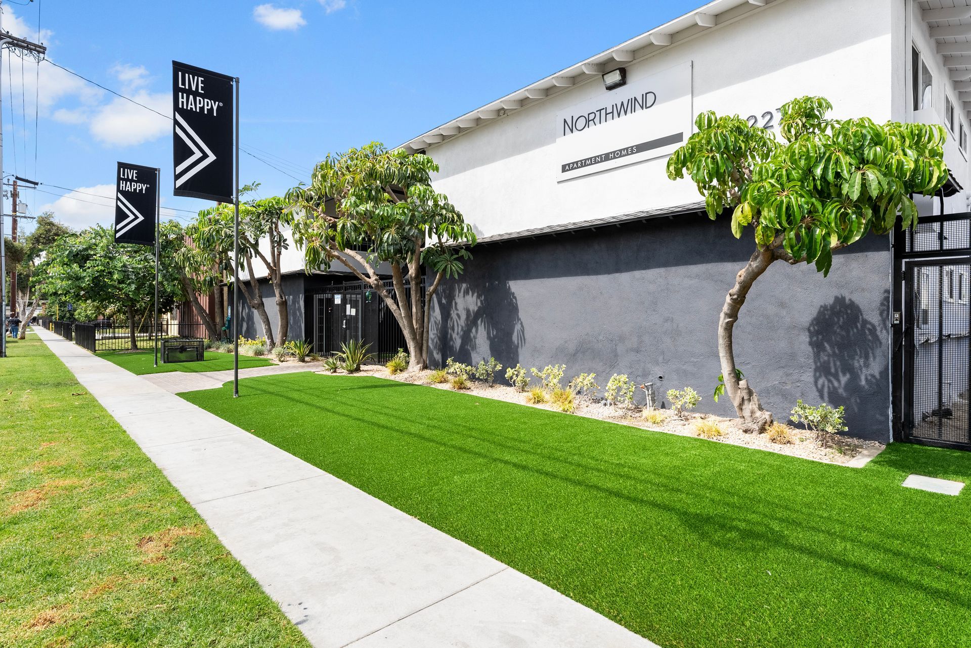 Gallery of exterior and interior photos of Northwind. Including walkways, gray archways, blue front doors, bbq grills, bedrooms with furniture, gated entrances, and main office.