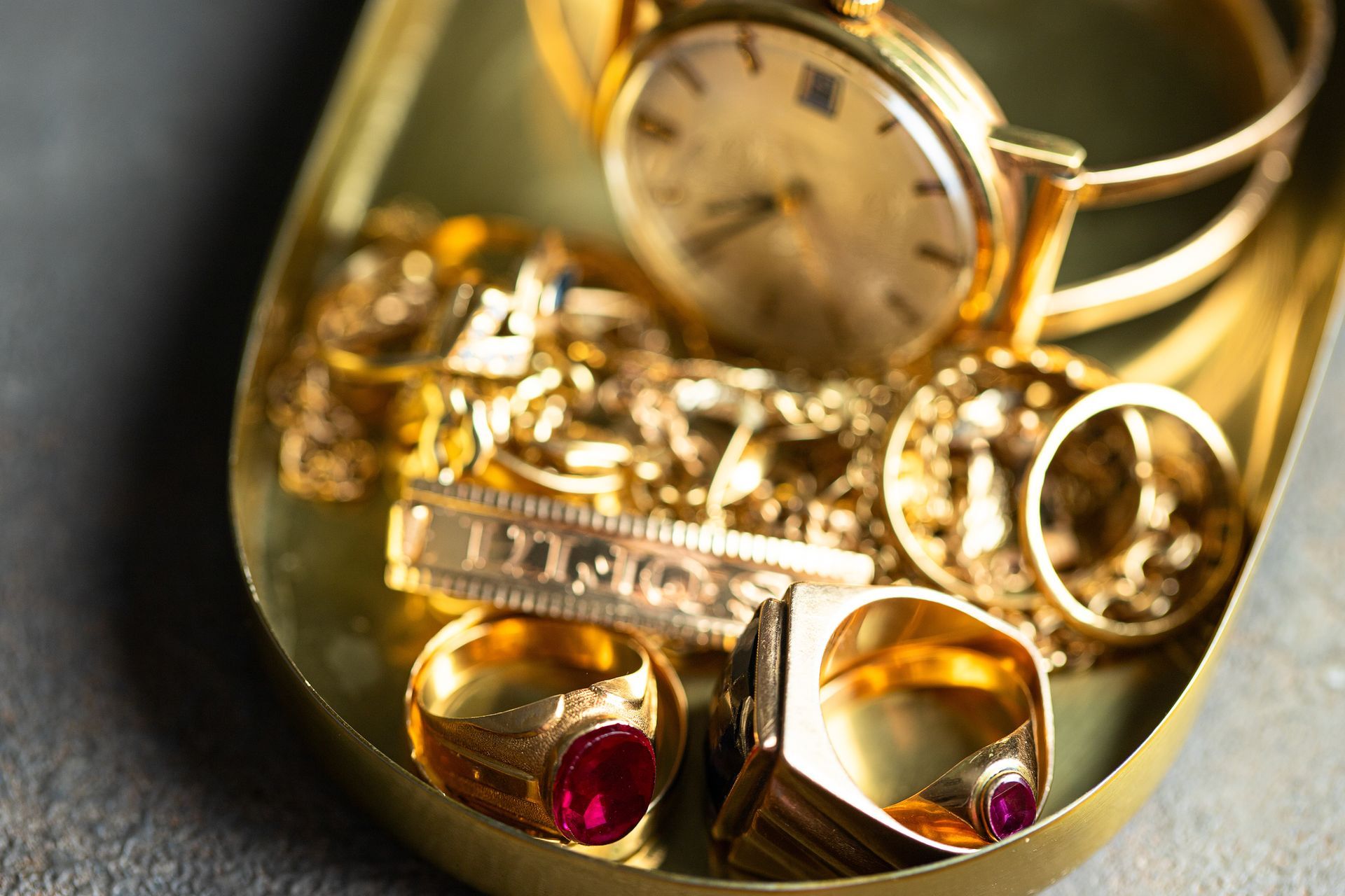 A collection of gold jewelry displayed elegantly in a gold-lined box.