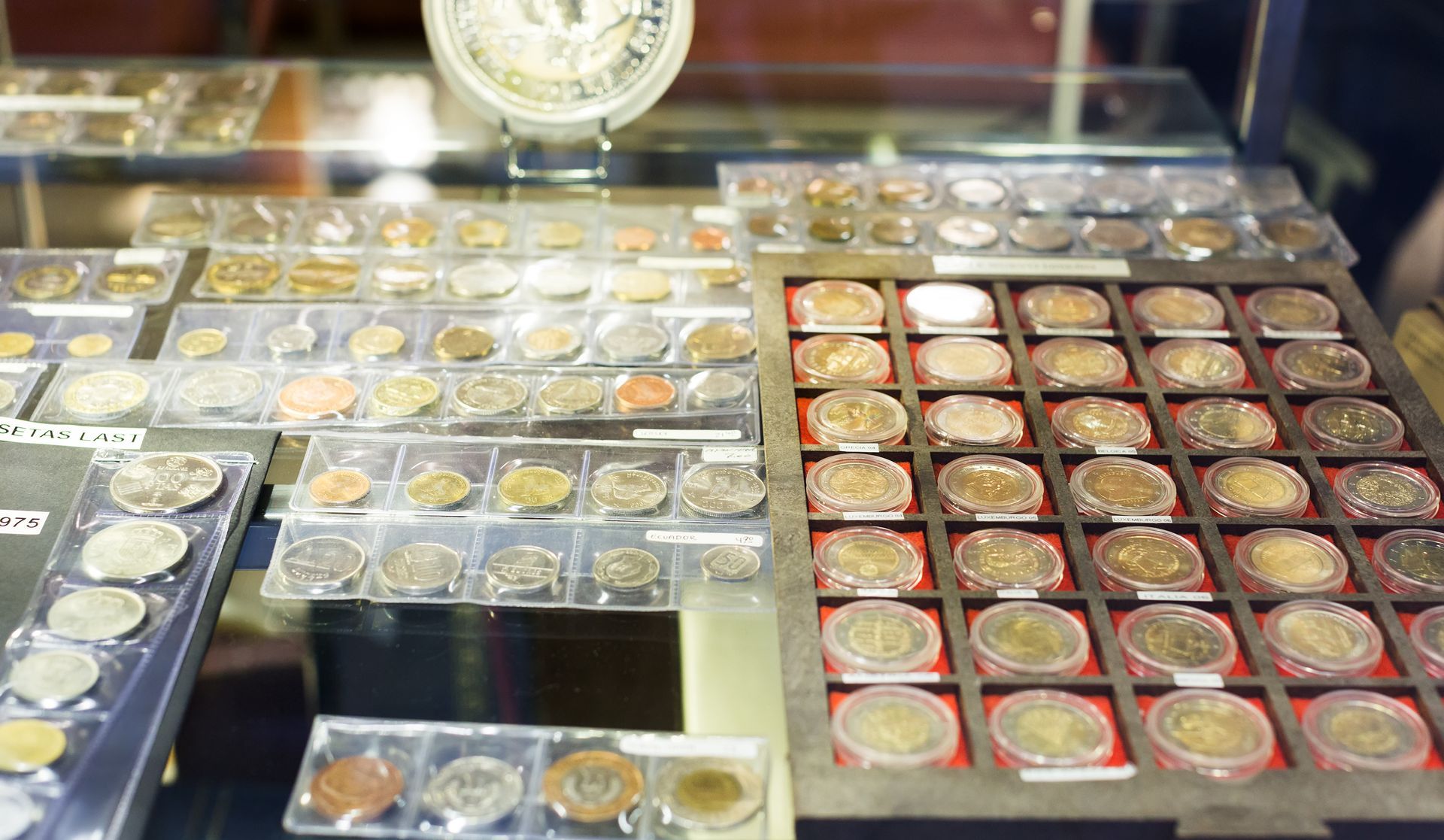 Coin display case showing organized trays of assorted collectible coins. Coin display case showing organized trays of assorted collectible coins.