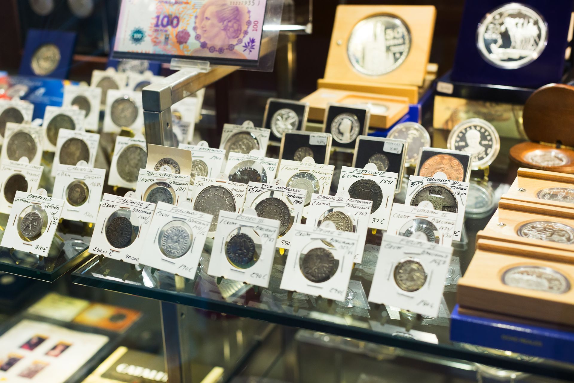 Display case filled with labeled collectible coins and currency.