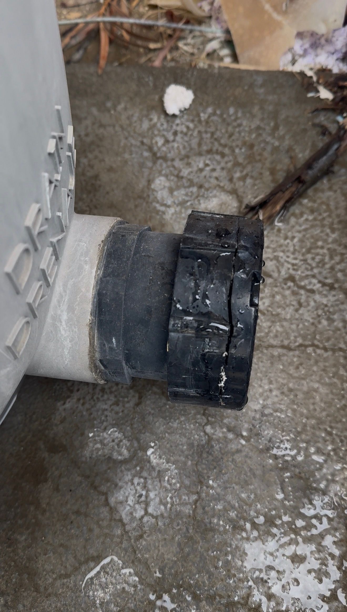 Worn black filter drain plug leaking at the base of a pool filter before replacement
