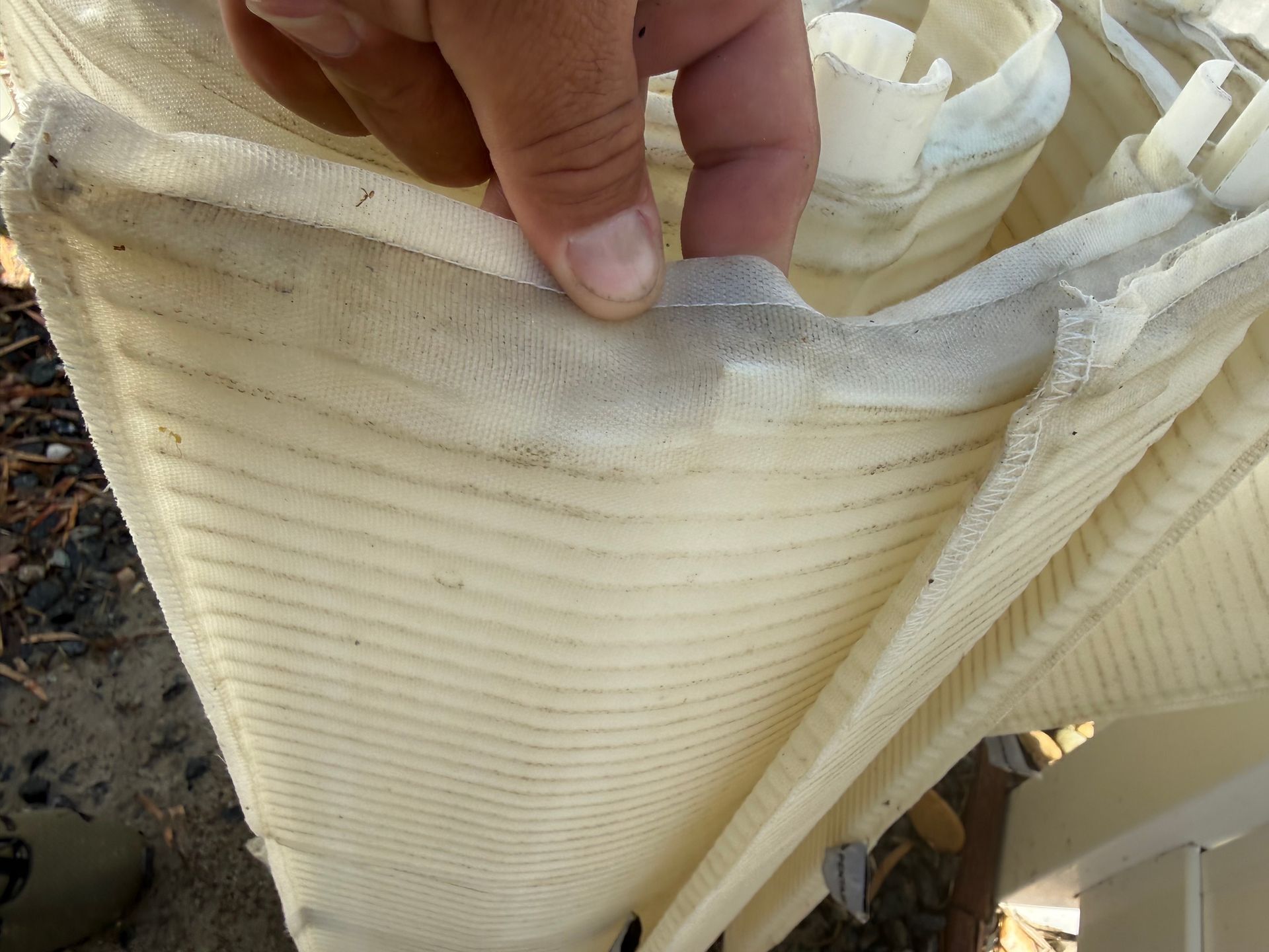 Worn DE pool filter grid with torn, split fabric removed during a filter replacement in Hemet, CA