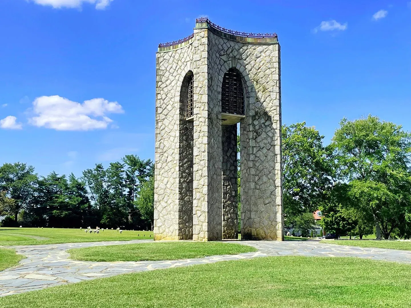 Stone memorial tower in a grassy park under a blue sky