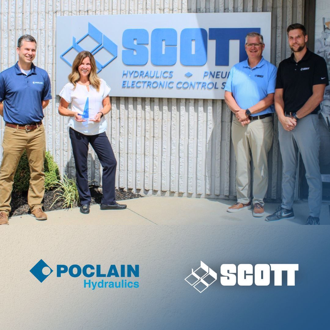 A group of people standing in front of a sign that says SCOTT.