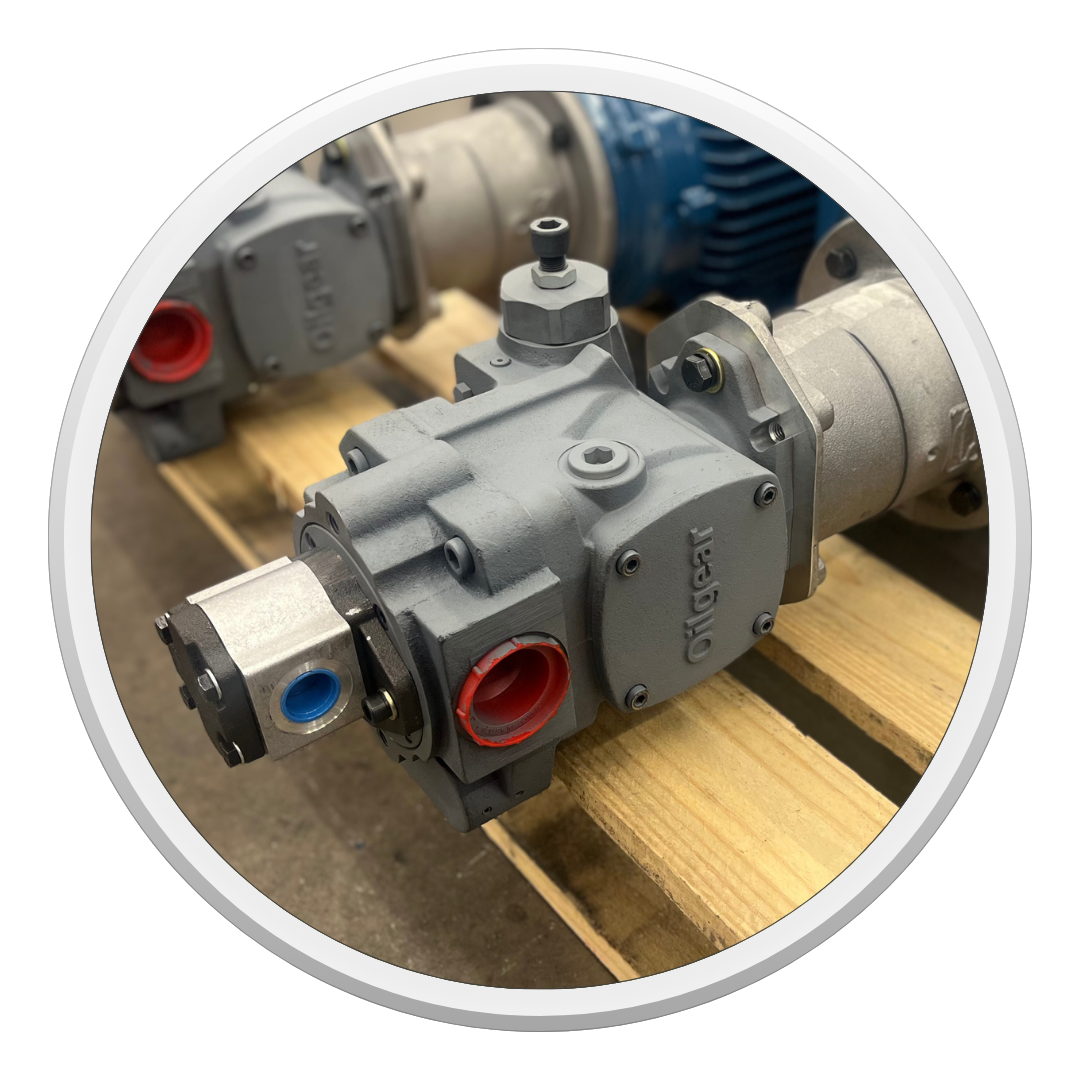 Gray industrial pump or valve assembly with red and blue ports on a wooden pallet. PVM pump by Oilgear built by Scott Industrial Systems