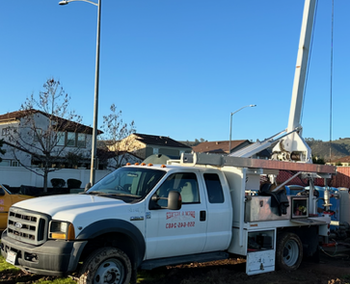 A white truck with a crane on the back of it