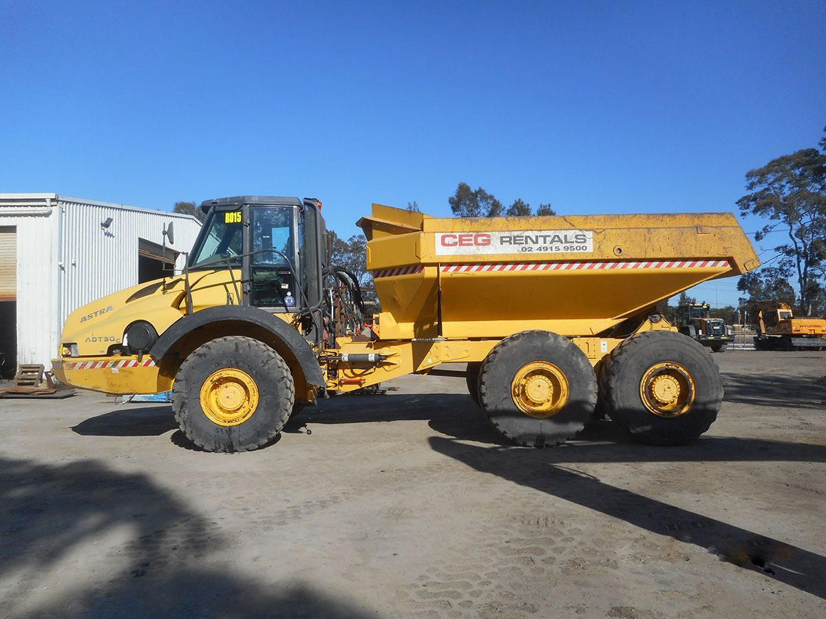 A yellow dump truck is parked in a parking lot.