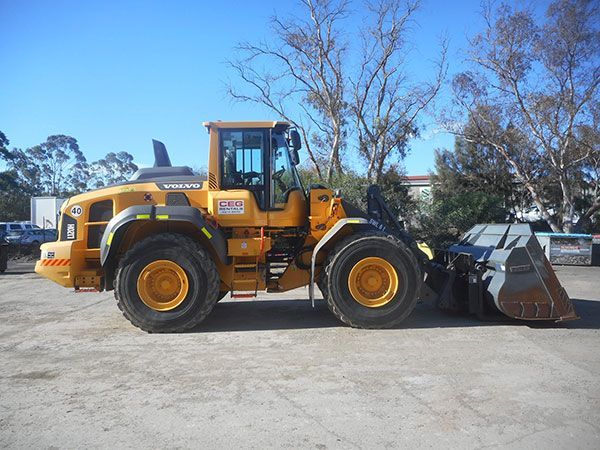 A yellow wheel loader is parked in a parking lot