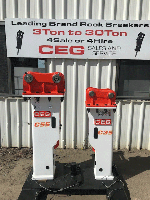 Two ceg rock breakers are sitting in front of a building