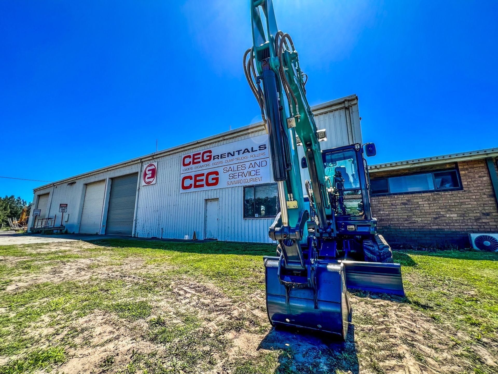 A large excavator is parked in front of a building.