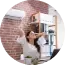 Person painting a brick wall with a brush in a bright room