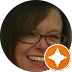 Smiling person with glasses in a dim selfie, with an orange star sticker covering part of the face