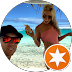 Smiling people at the beach with blue sky and ocean, one taking a selfie