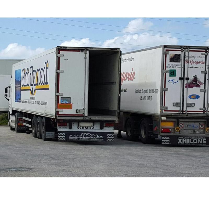 due camion sono parcheggiati uno accanto all'altro e uno ha la scritta xhilone sul retro