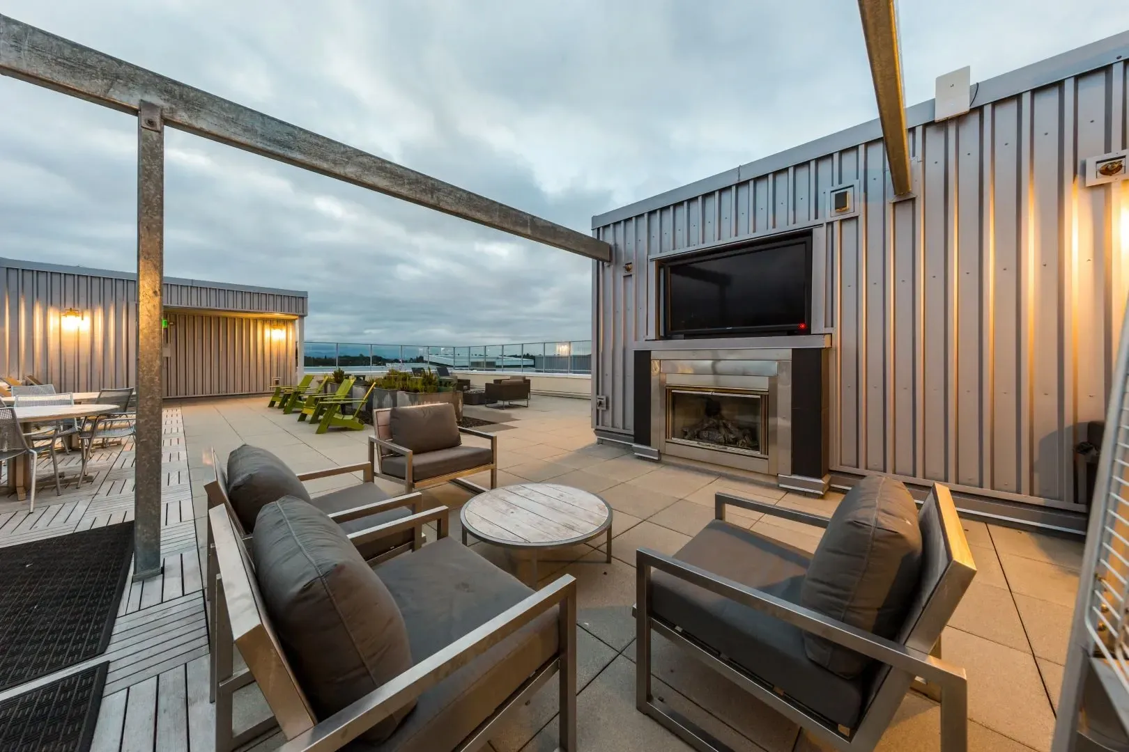 Rooftop lounge area with seating, fireplace, and television.