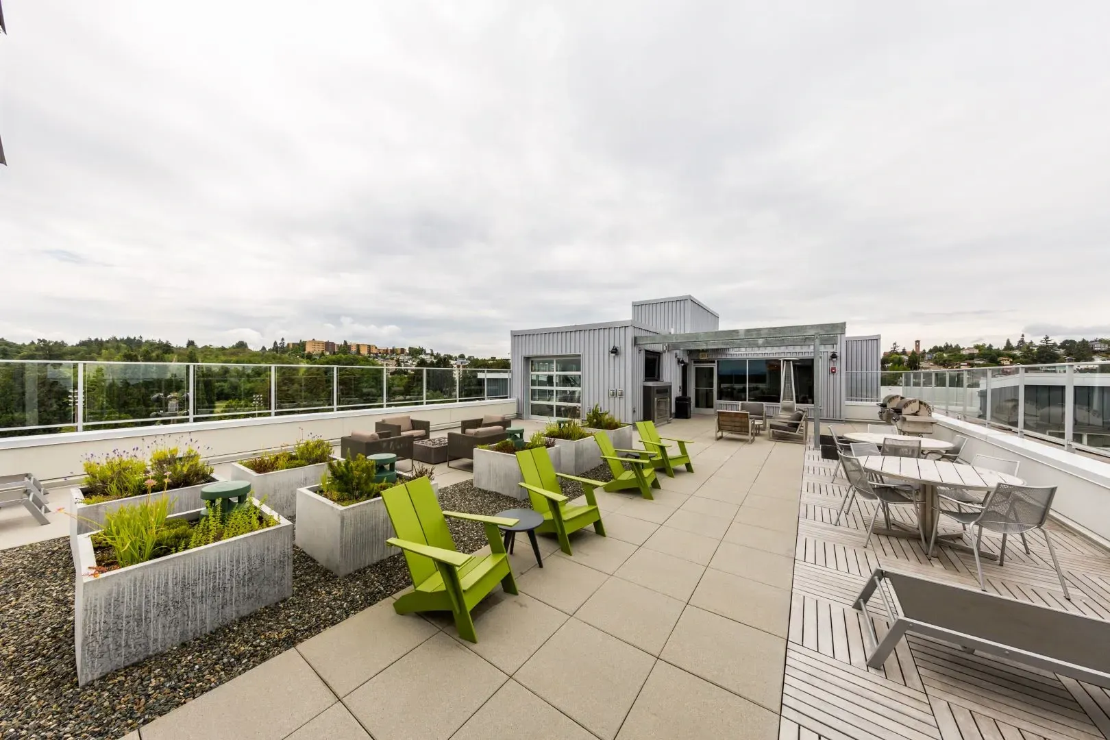 Rooftop terrace with lounge seating, dining tables, and planters.