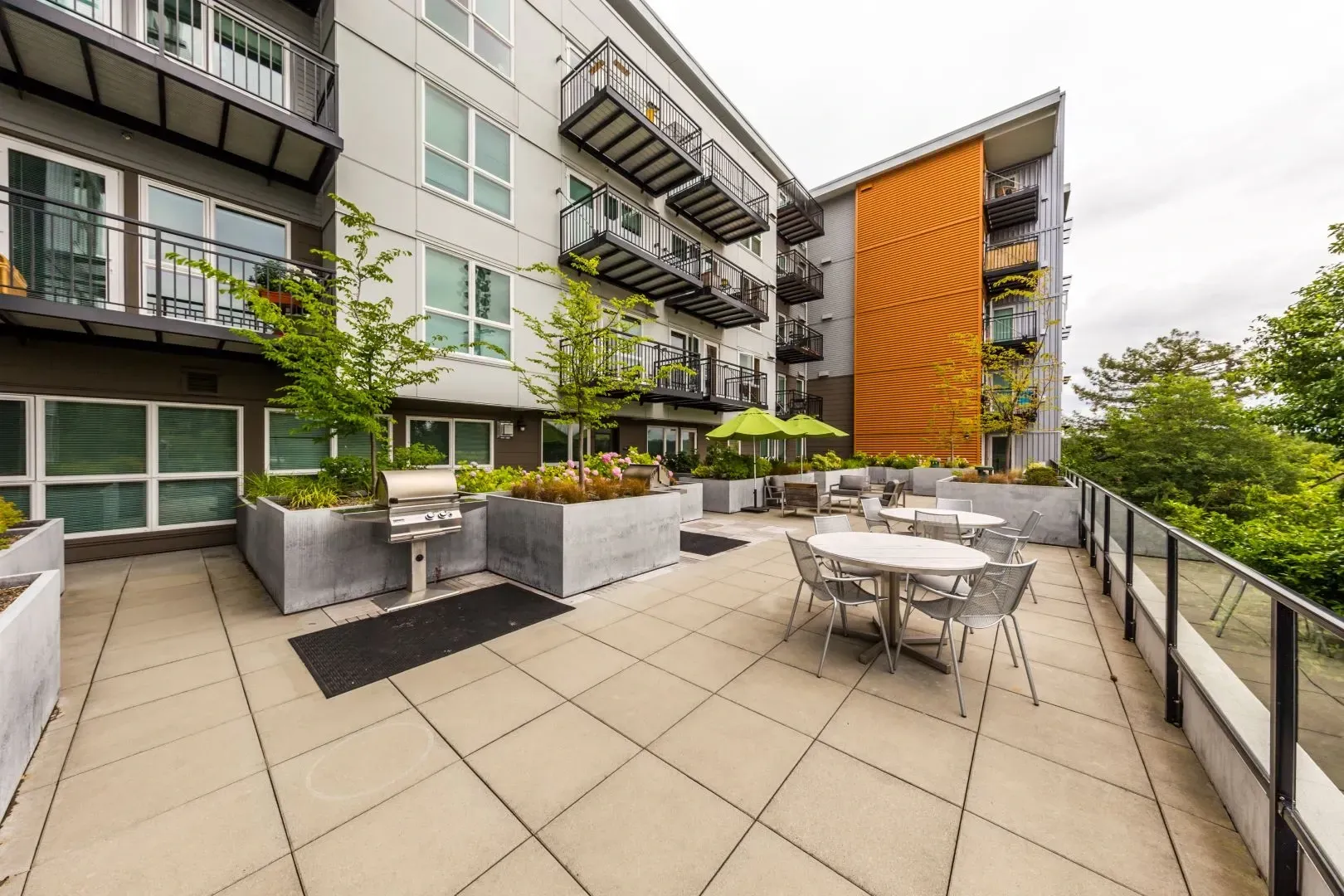 Outdoor patio with tables, chairs, and a grill area.
