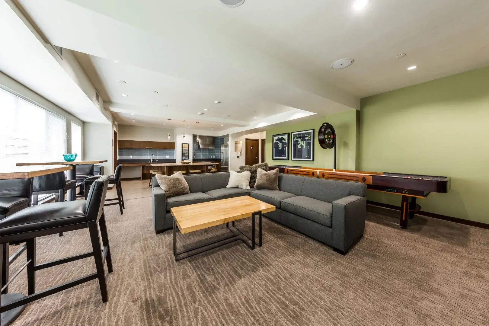Community lounge area with seating, shuffleboard, and dartboard.