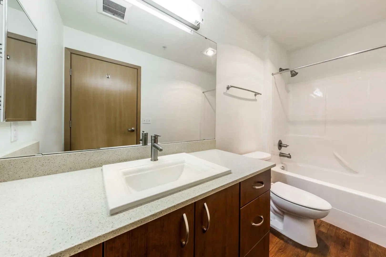 Bathroom with vanity, sink, toilet, and bathtub with shower.