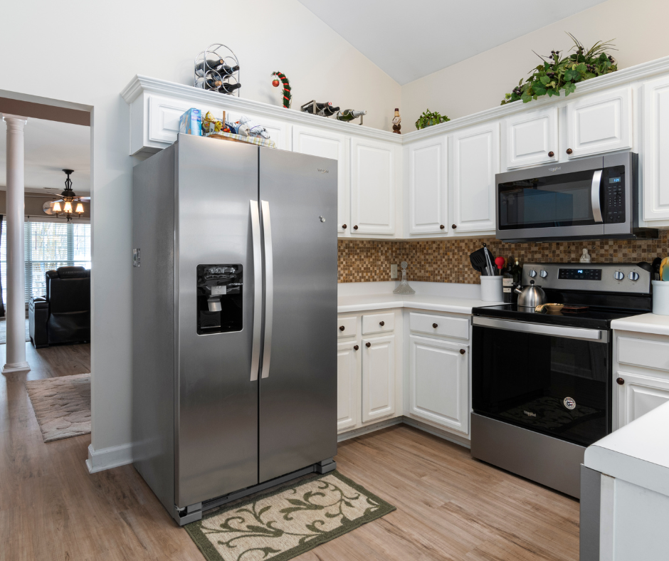 A kitchen with stainless steel appliances and white cabinets.