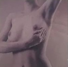 Primo piano del torso nudo e della mano di una persona, tinti con tenui tonalità rosa.