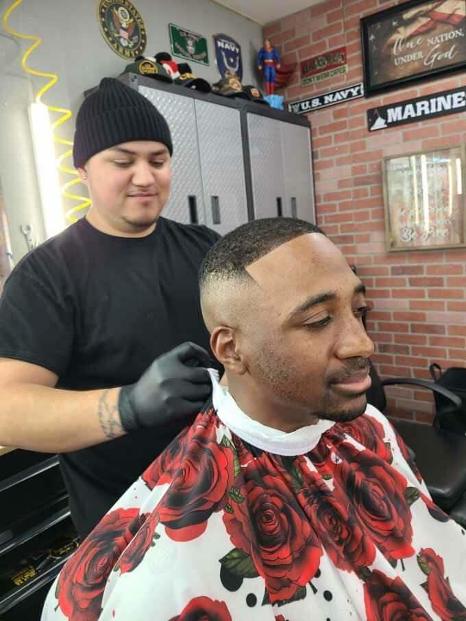 A man is getting his hair cut by a barber in a barber shop.