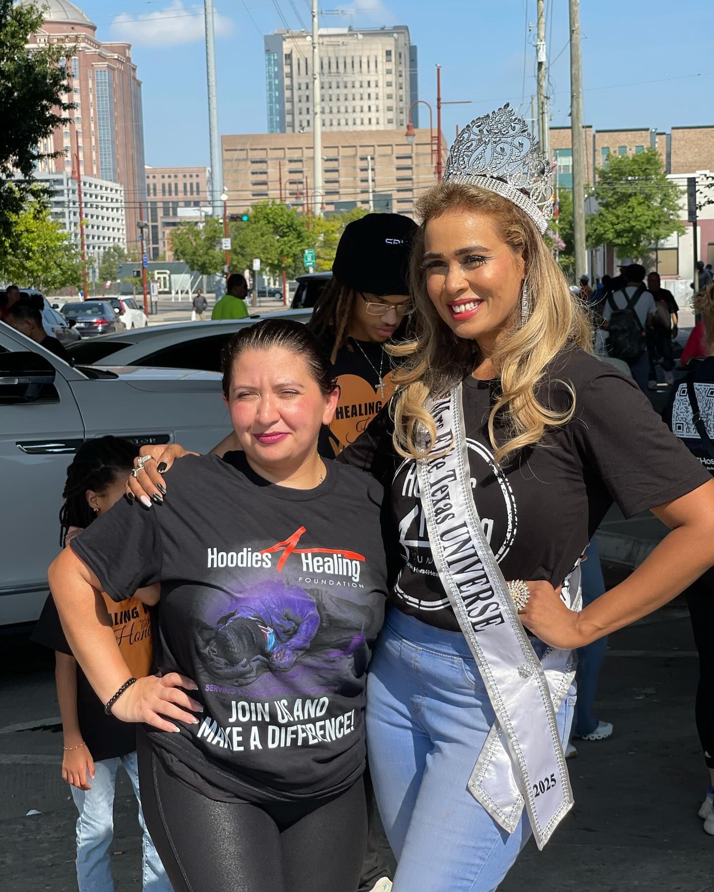 Two women are posing for a picture and one of them is wearing a crown.