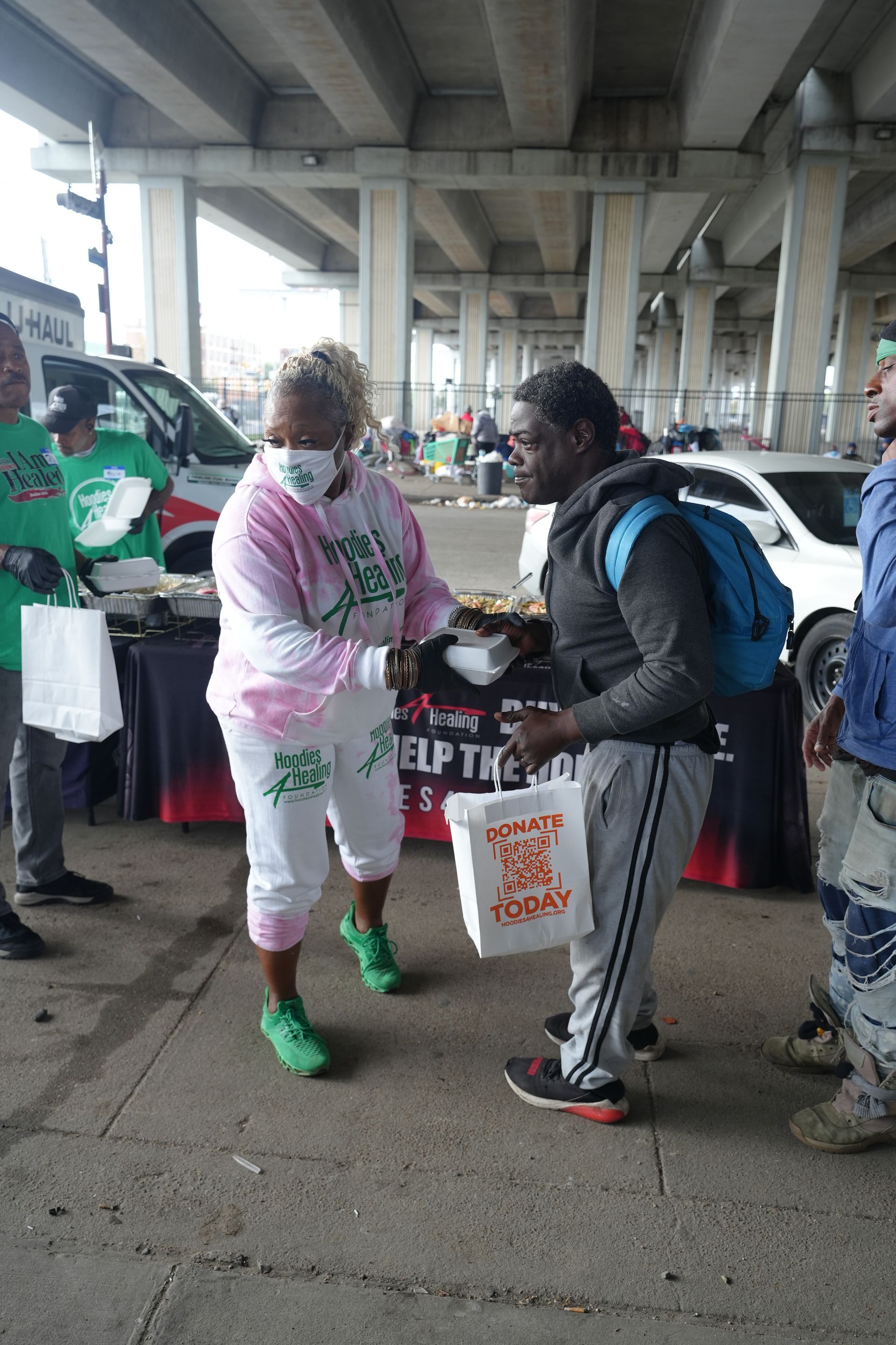 A man is standing next to a woman holding a bag of food.