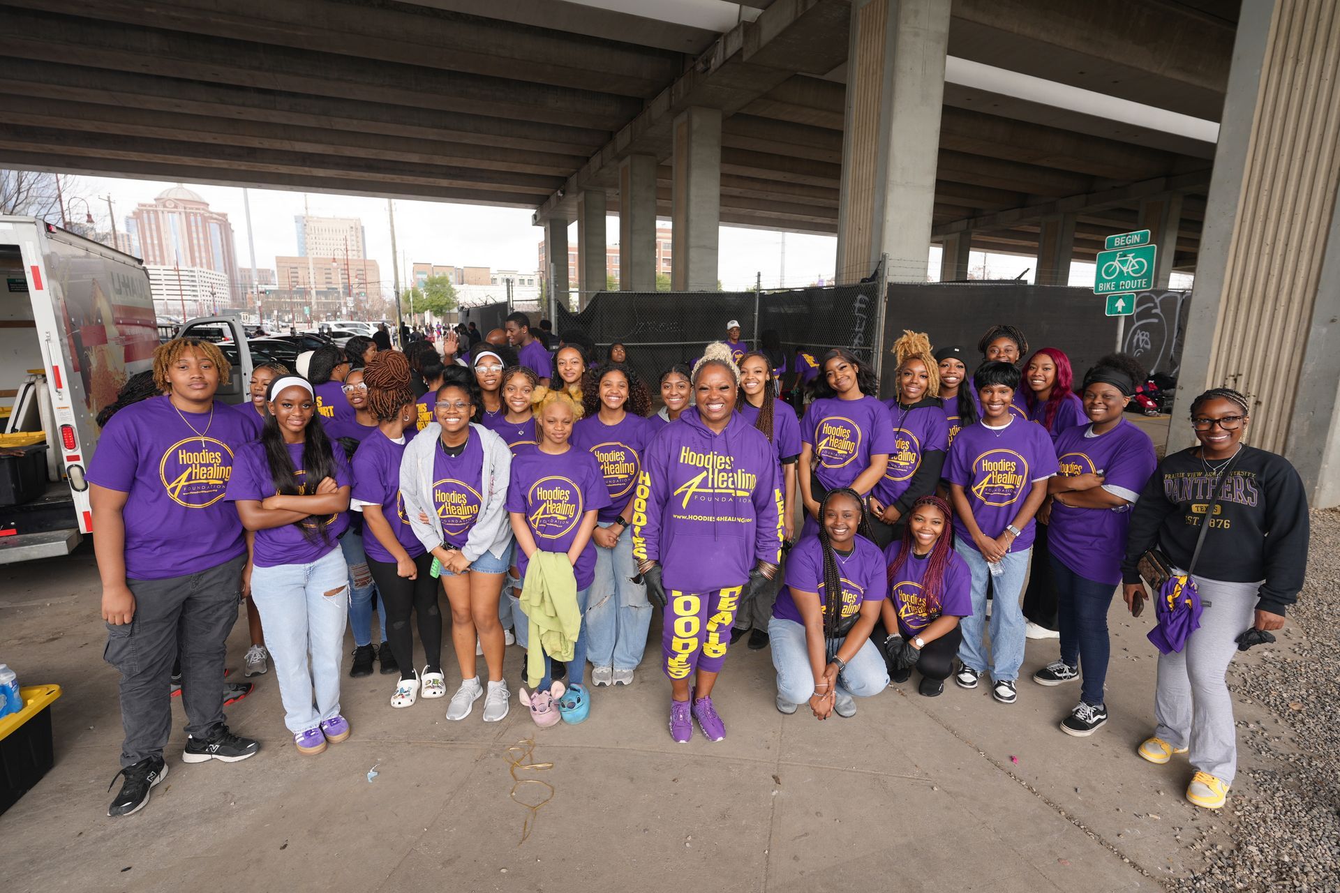 A group of people are posing for a picture under a bridge.