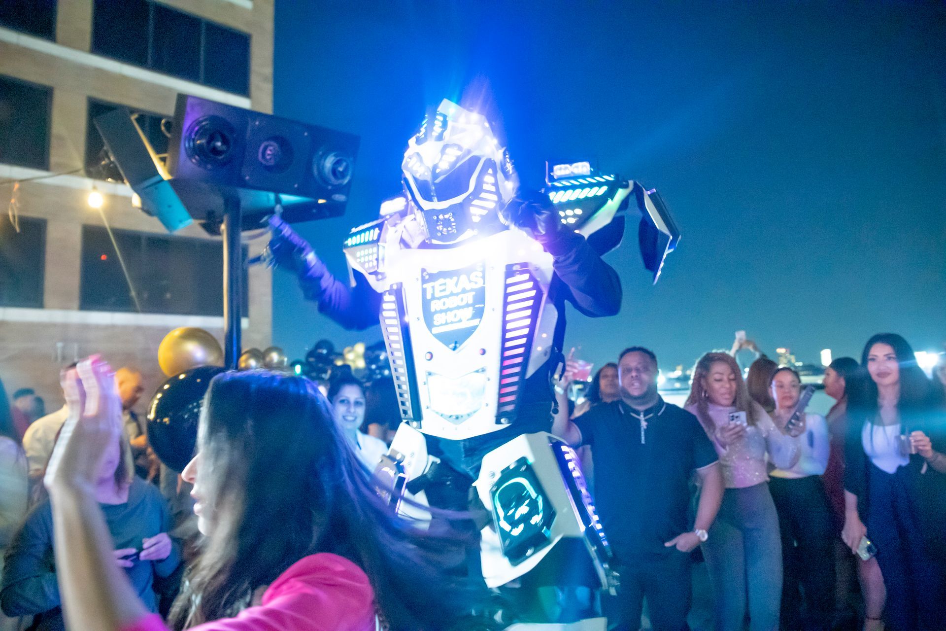 A woman is taking a picture of a robot at a party.