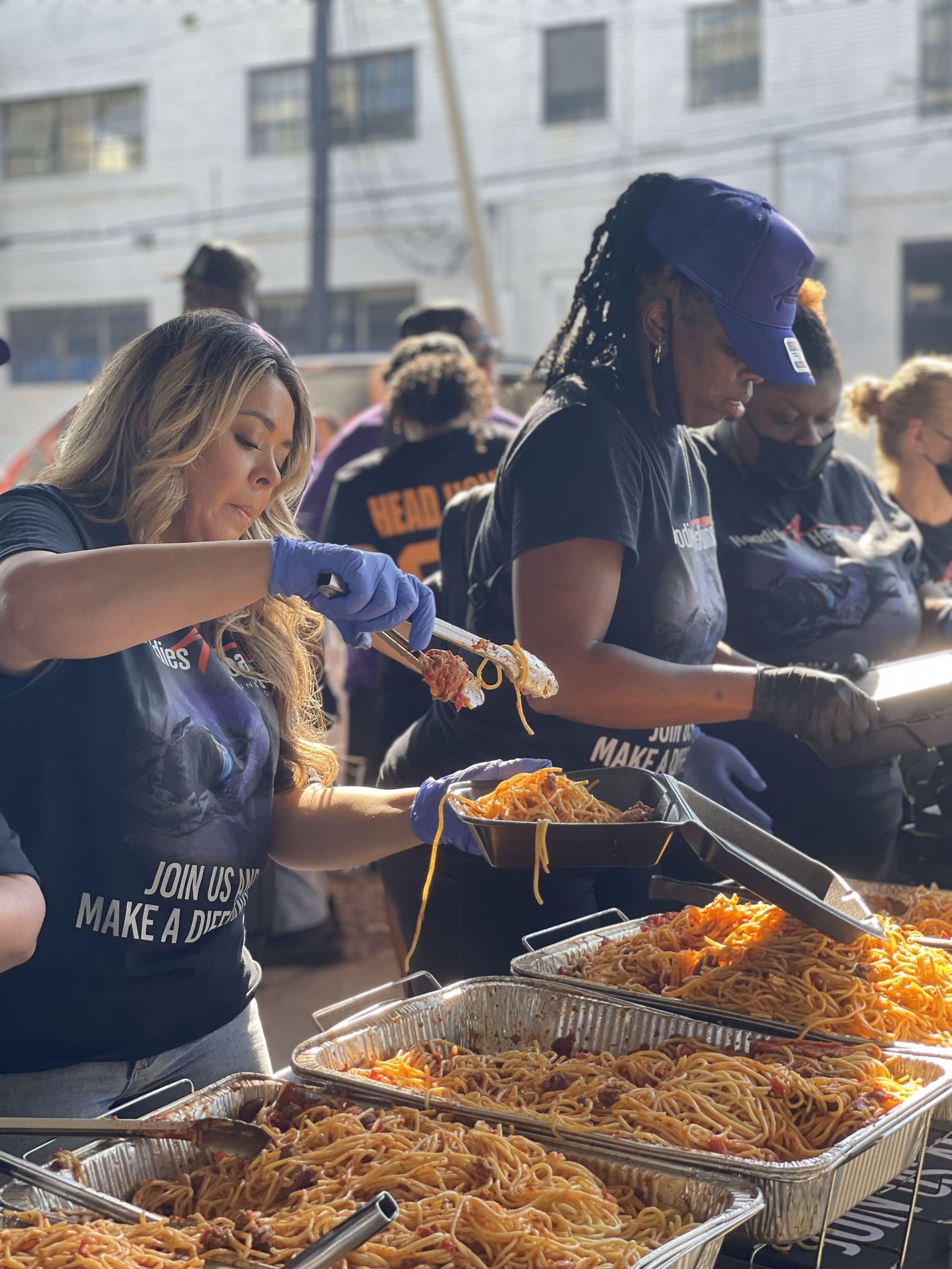 A group of people are serving food at a buffet.