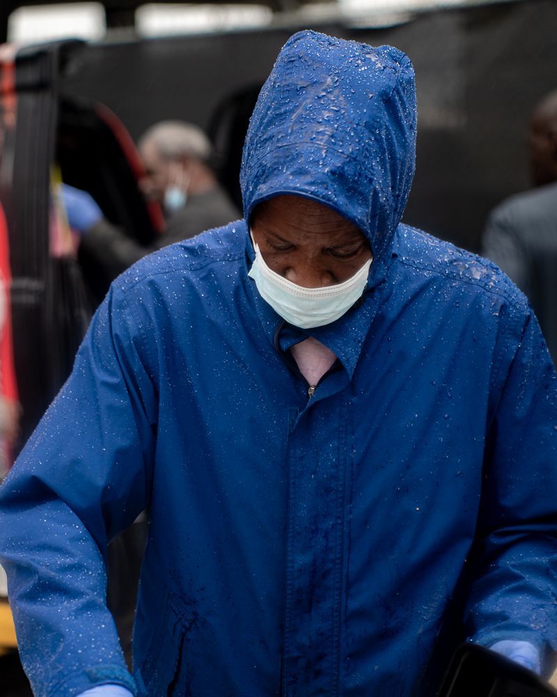 A man wearing a mask and a blue jacket with a hood