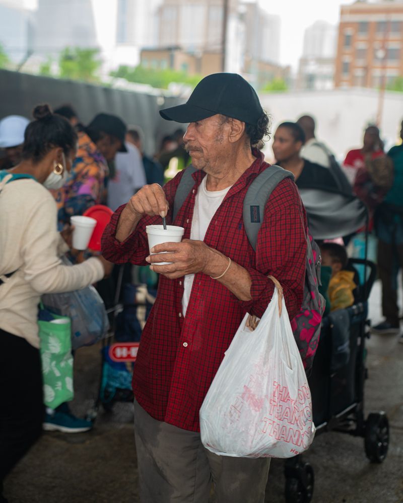 A man in a red shirt is holding a cup of coffee