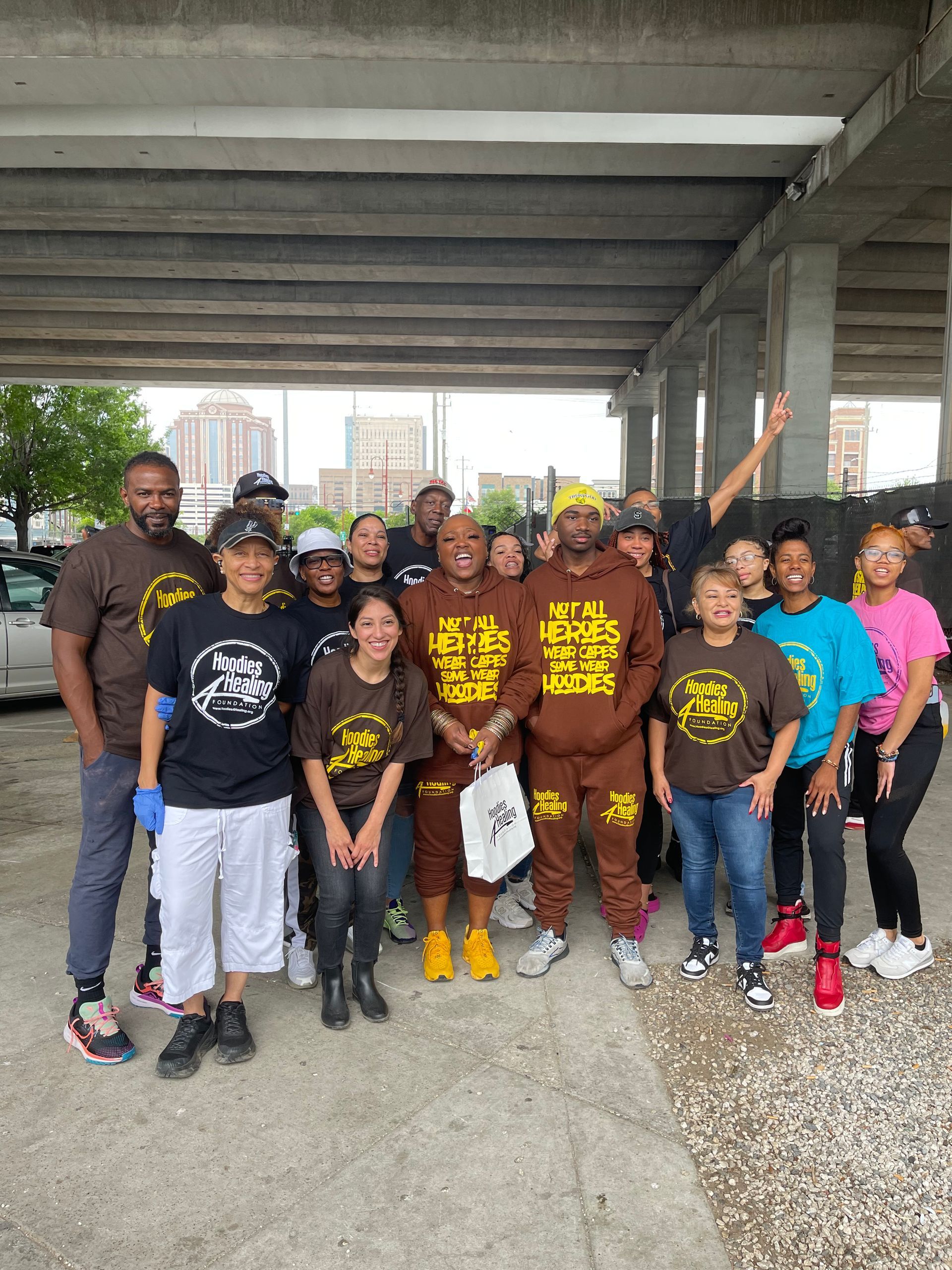 A group of people are posing for a picture under a bridge.