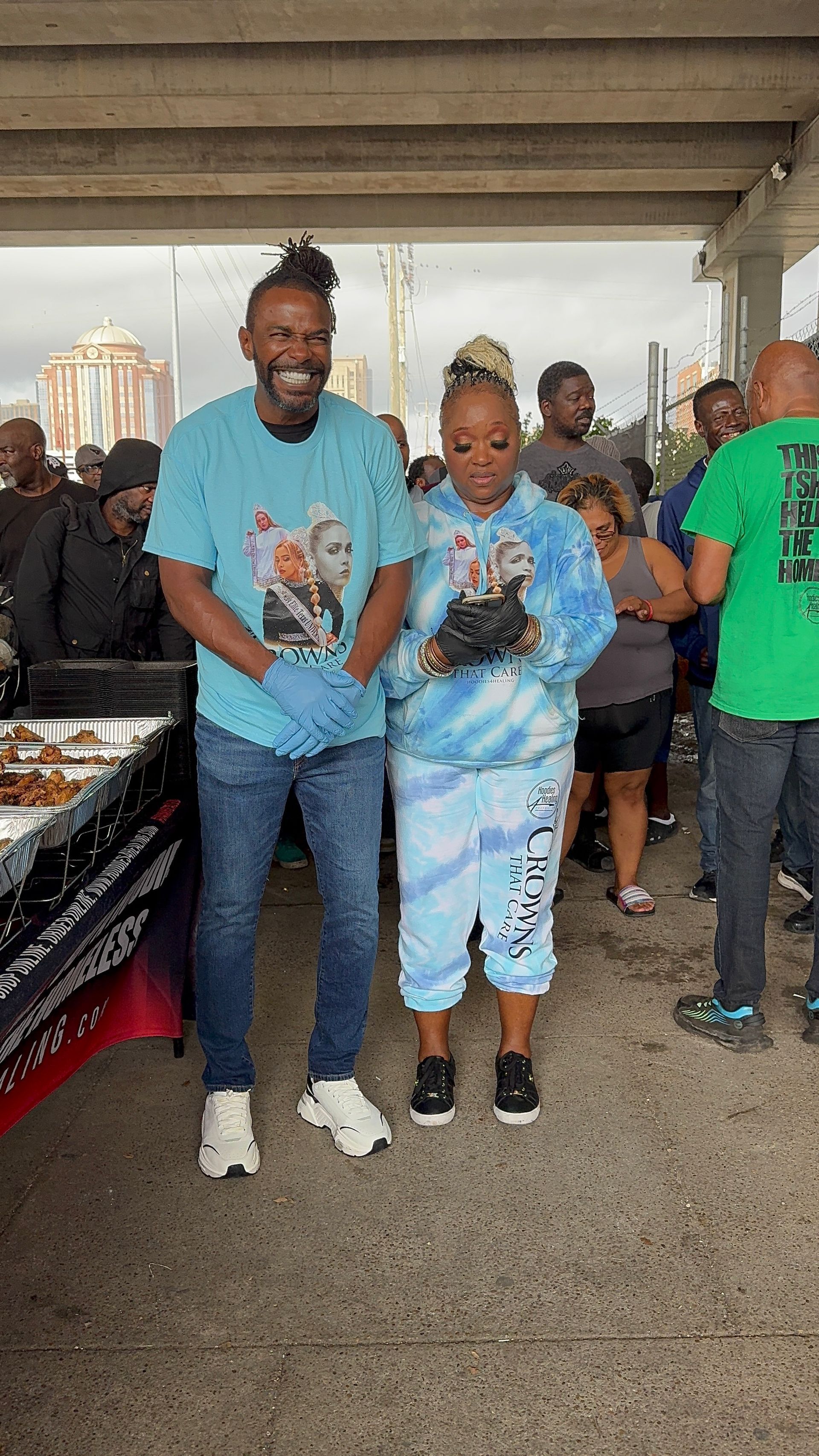 A man and a boy are standing next to each other in front of a crowd of people.
