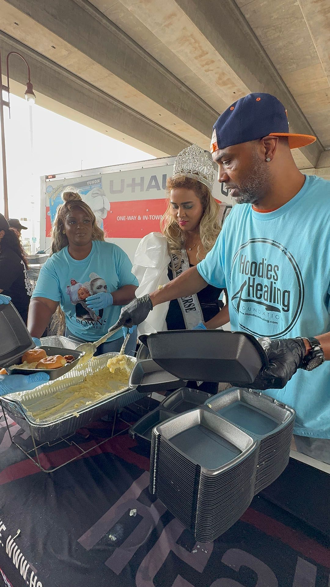 A man in a blue shirt is cooking food at a table.