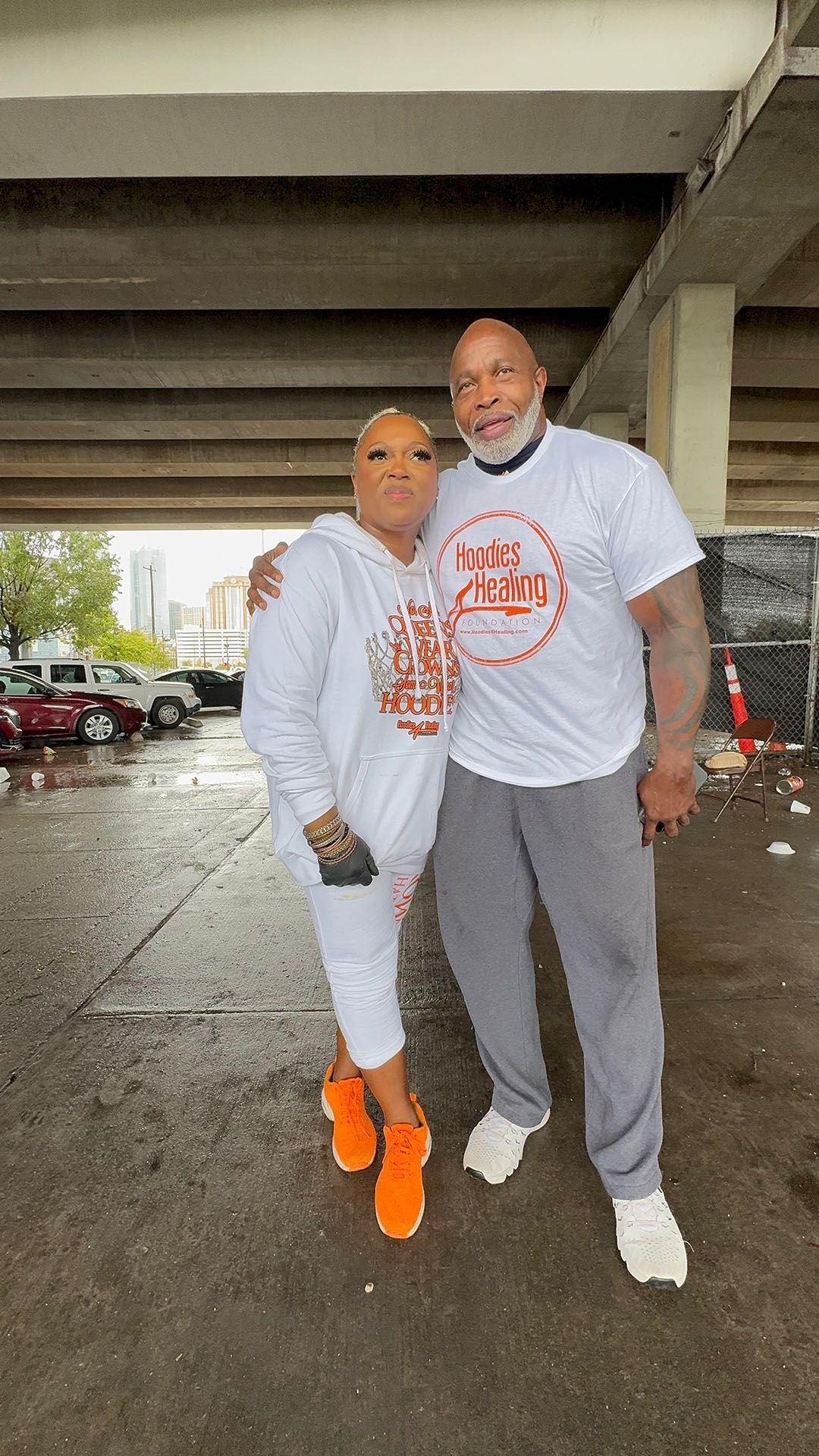 A man and a woman are posing for a picture under a bridge.