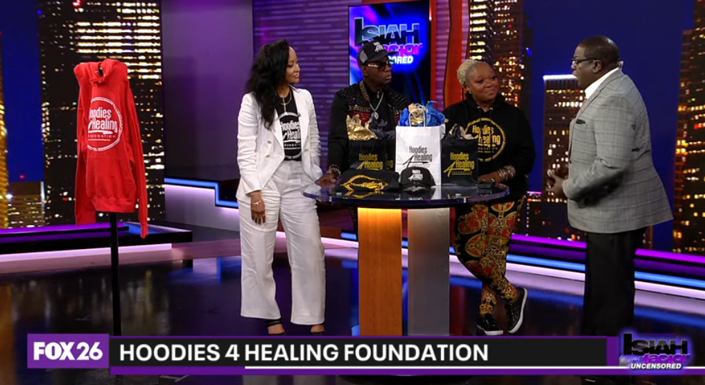 A group of people are standing around a table on a television show.