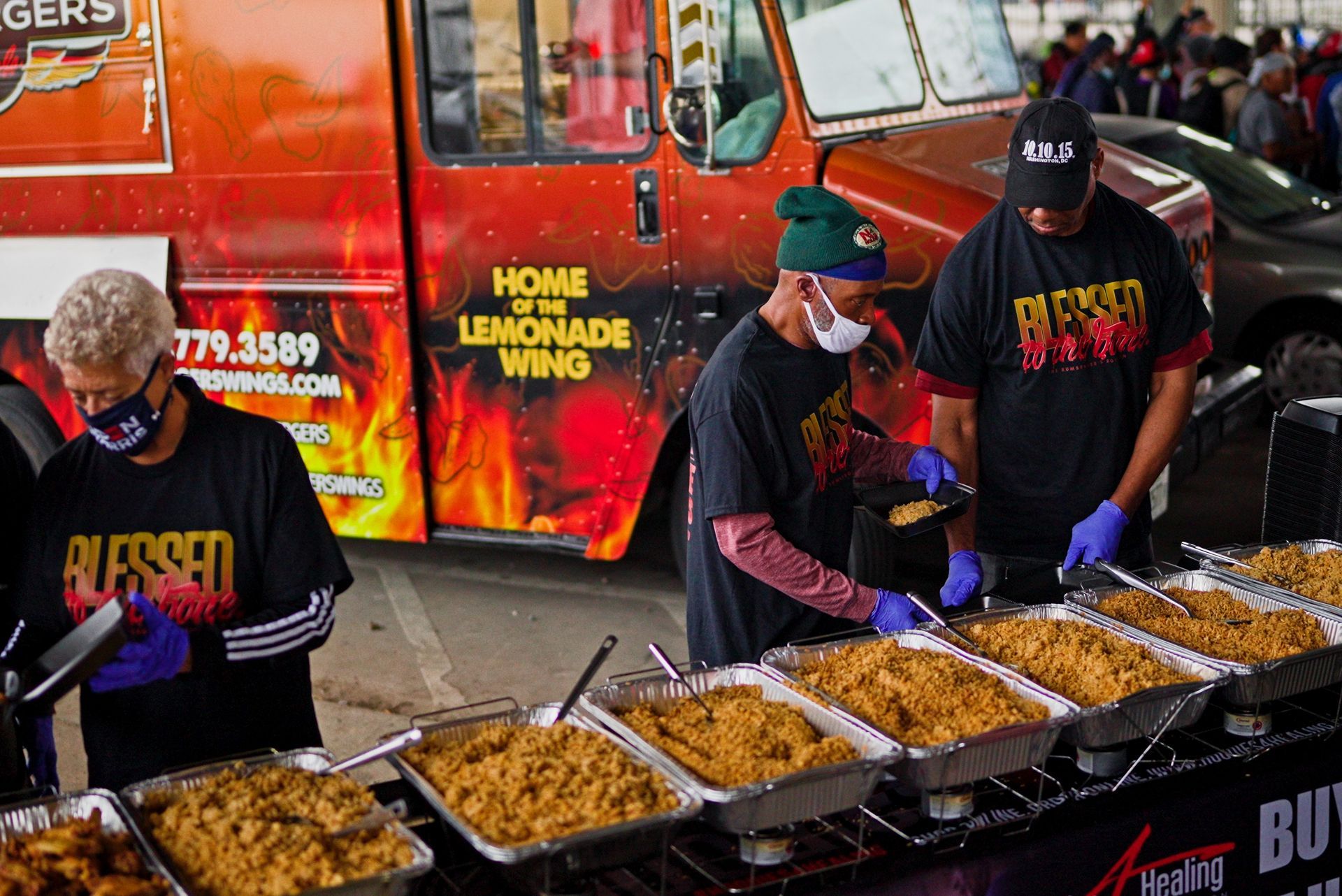 A group of people are preparing food in front of a food truck.