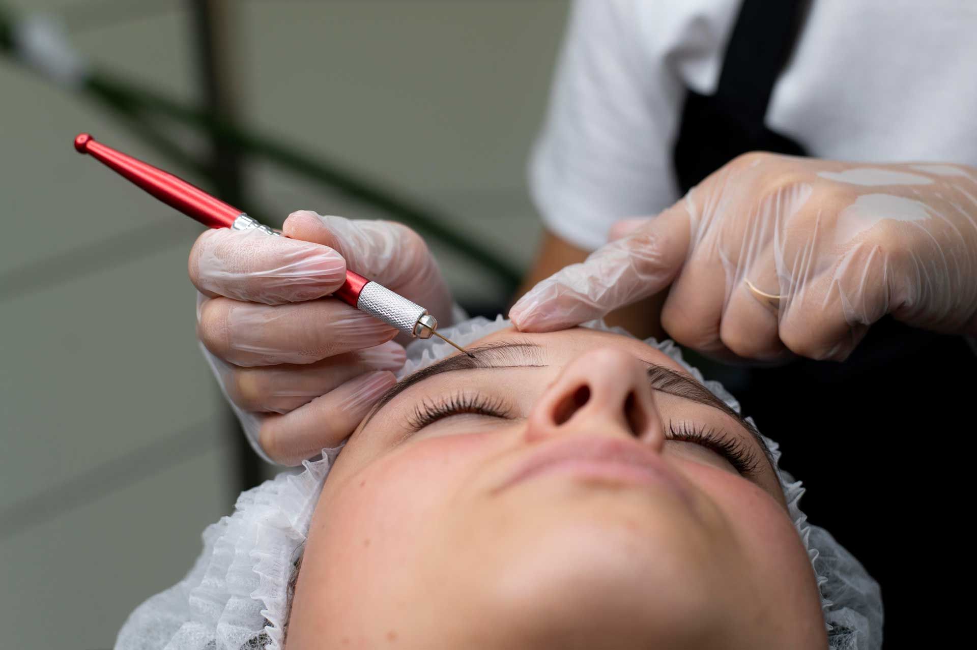 A woman is getting her eyebrows done at a beauty salon.