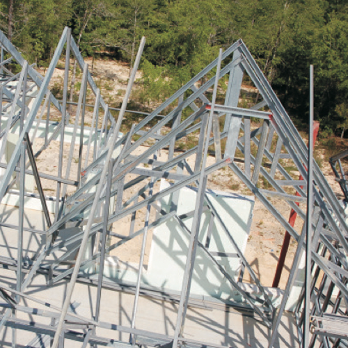 a large metal structure is being built with trees in the background