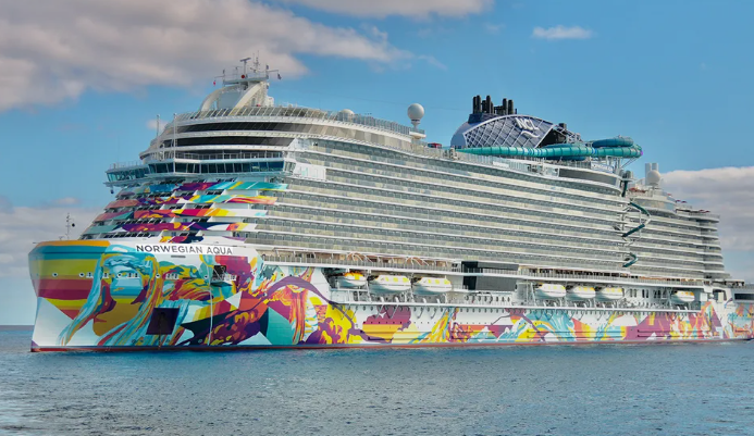 Large colorful cruise ship on ocean, clear sky. Artwork on hull.