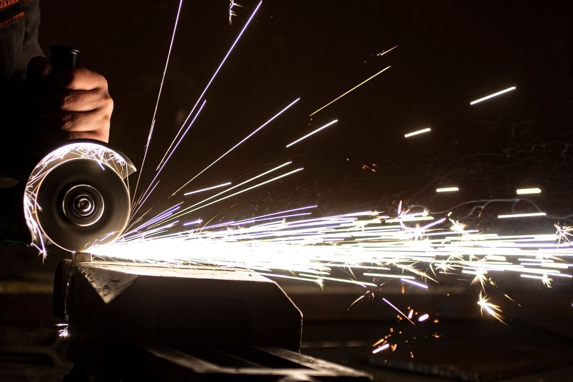 Close up of a worker cutting metal with an angle grinder, creating bright sparks. Close up of a worker cutting metal with an angle grinder, creating bright sparks.
