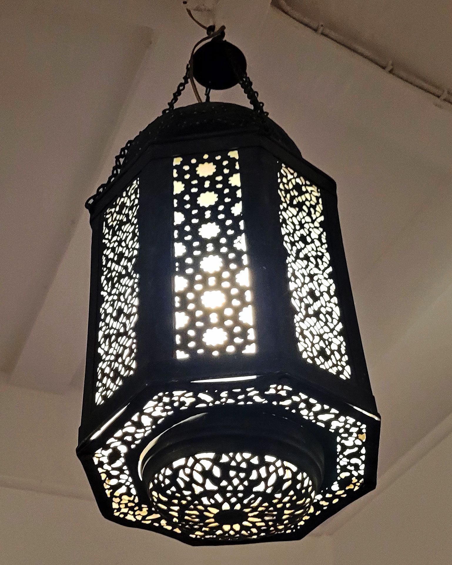 An antique copper lamp on a historic boat sailing the Nile. The boat is the Dahabiya Kingfisher, which was built in 1899 and offers private cruises between Luxor and Aswan in Egypt.