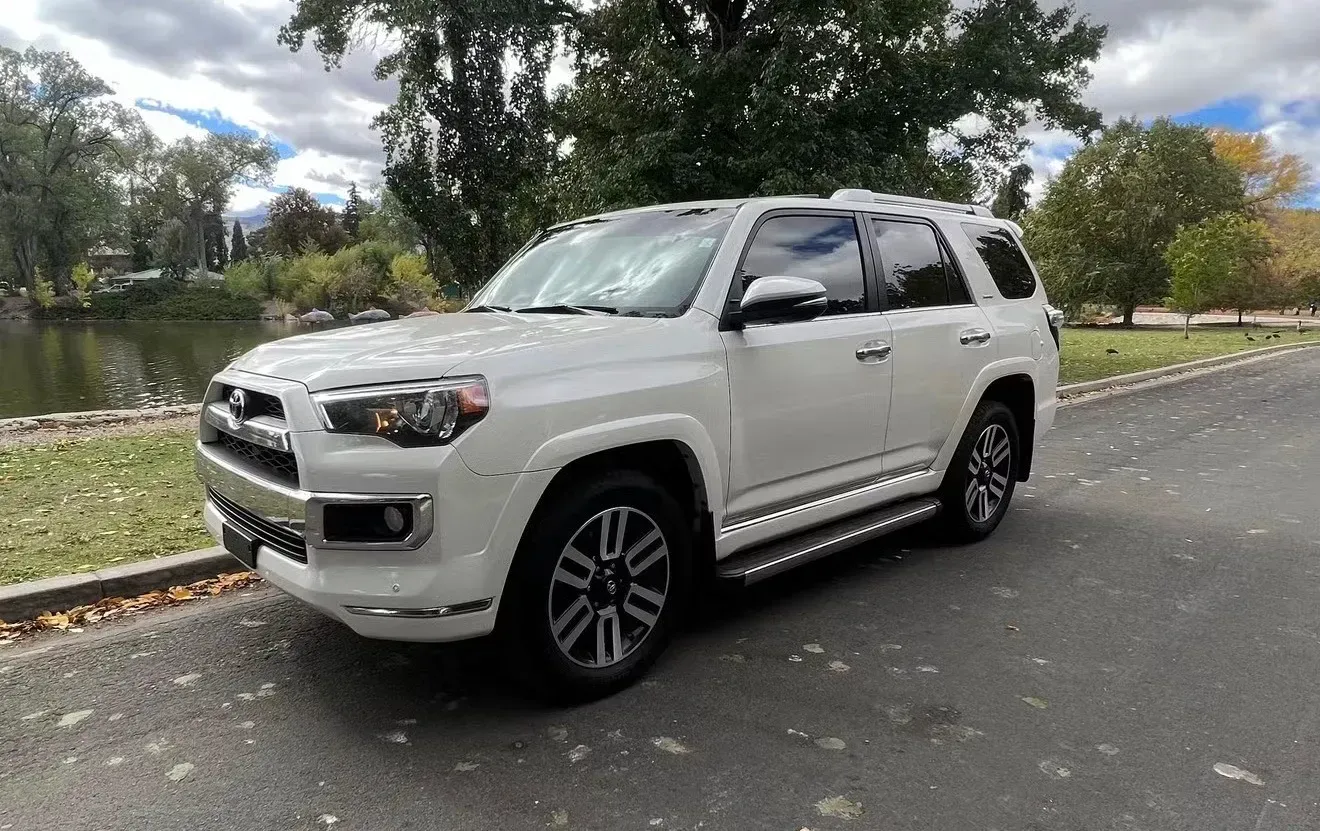 White Toyota 4Runner parked on a road beside a body of water with trees in the background | Nonstop Auto Reno, NV
