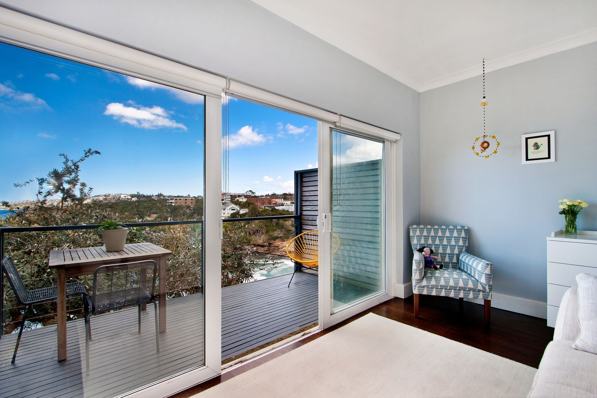 Bright modern bedroom featuring large sliding glass doors. 